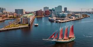 Norfolk Virginia harbor with red-sailed schooner